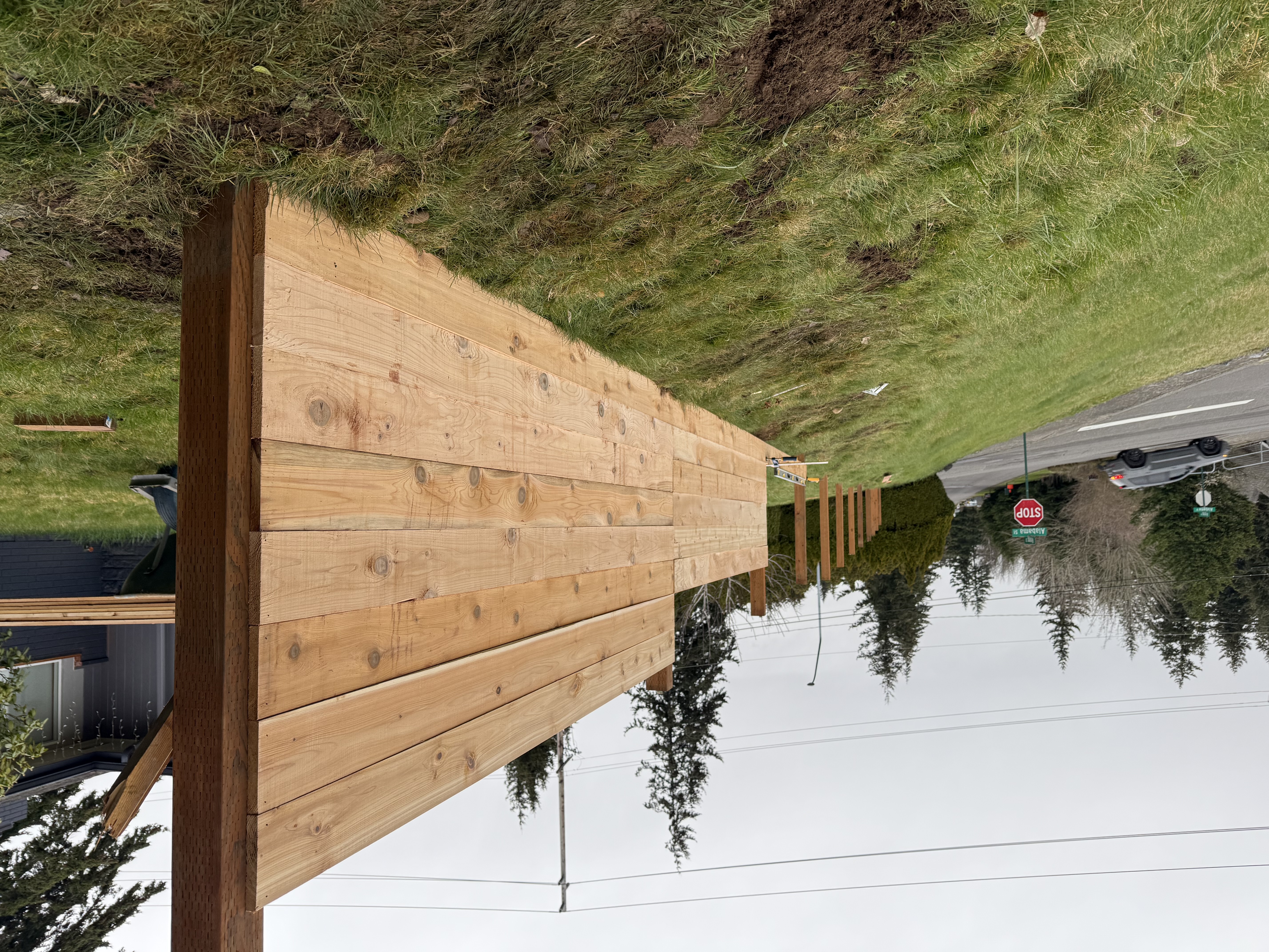 New cedar fence above a stone retaining wall